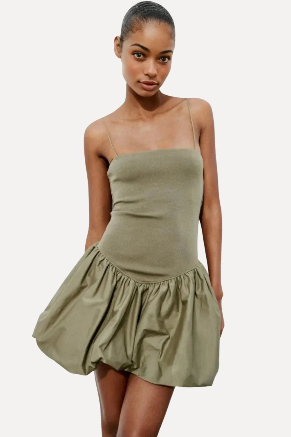 Model from the back wearing the Kouvr Aubrey olive green drop waist mini dress with a sculptural bubble skirt