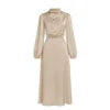 Model wearing Kouvr long sleeve beige satin midi dress with draped cowl neckline