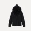 Woman wearing Kouvr black wool and cashmere blend hoodie with large fox fur trim hood