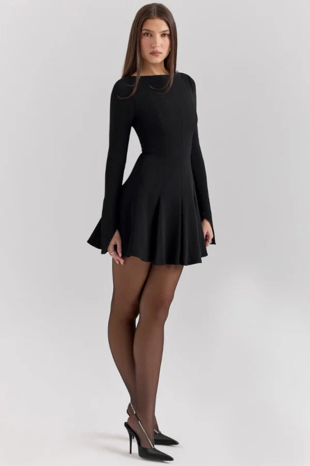 Model from behind wearing the Kouvr Fashion black long sleeve mini dress, showing the button details on the split cuffs