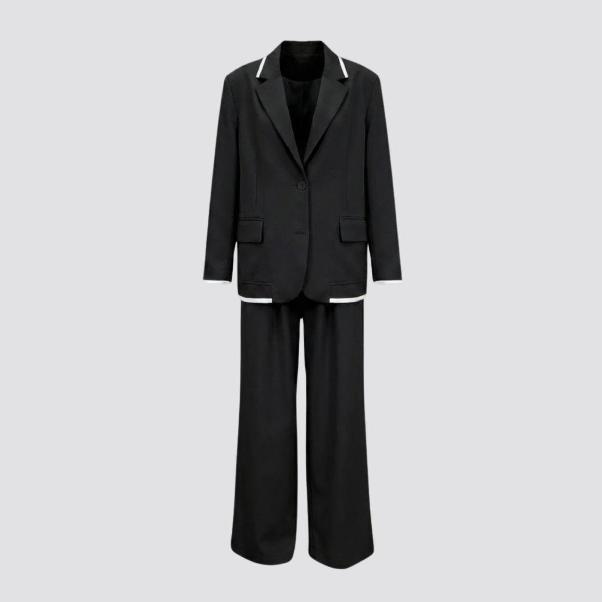 Flatlay product shot of the Kouvr black pantsuit for women, showing the single-breasted blazer with white trim and matching wide-leg trousers.
