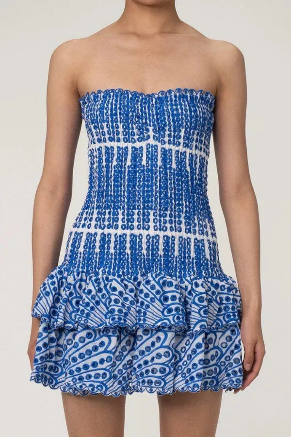 Model wearing the Kouvr Starla blue embroidered strapless mini dress against a studio background