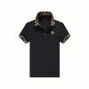 Flat lay of the Kouvr men's short sleeve black polo shirt, showing the full design including the button placket, gold R embroidery, and check-patterned collar and cuffs. 