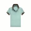 Product image of the Kouvr Fashion Brent men's polo shirt in mint green, showing the embroidered logo and brown and black checkerboard collar.