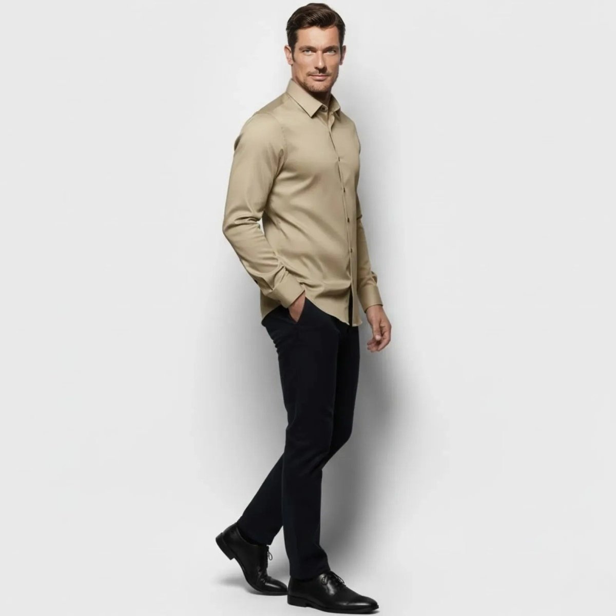 Side profile of a male model in the Kouvr Briar khaki long sleeve performance shirt, highlighting its tailored fit.
