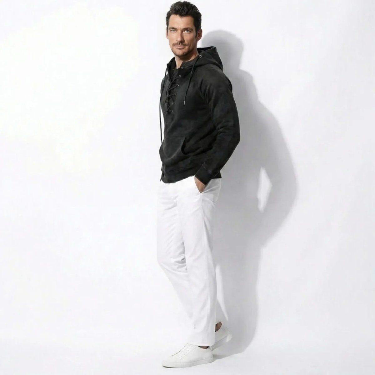 Side profile of a male model in the Kouvr Cannon premium cotton hoodie in washed black, showing the tailored fit and raglan sleeves.
