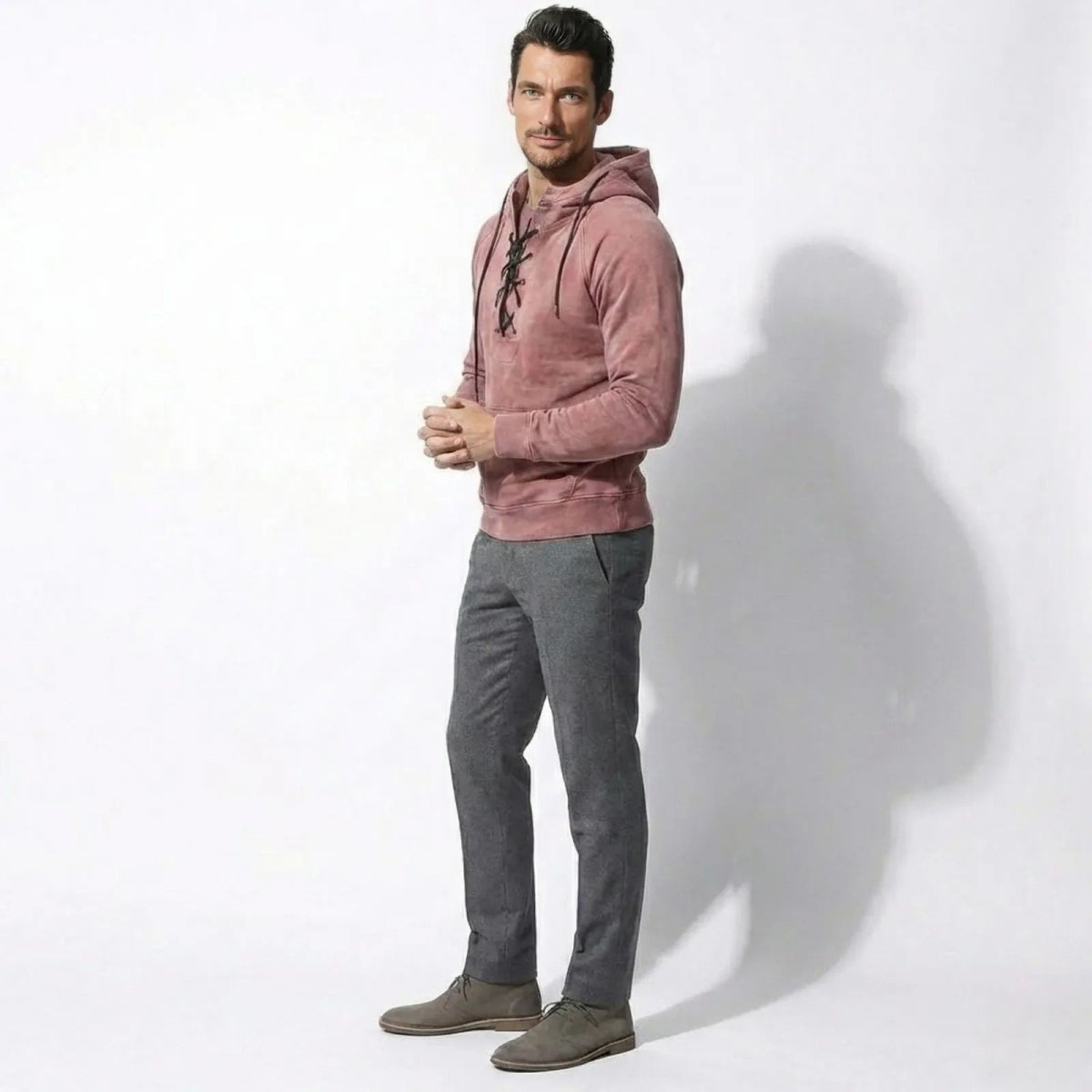  Side profile of a man wearing the tailored-fit Kouvr pink lace-up hoodie, showcasing its silhouette.
