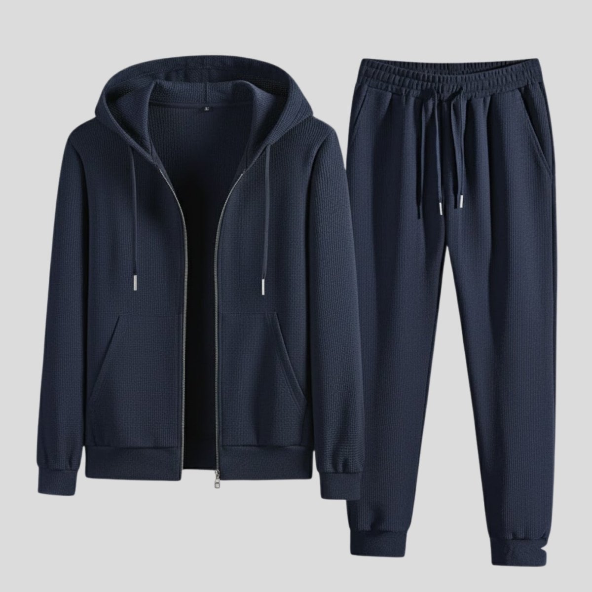 Flat lay of the Kouvr blue waffle knit loungewear set, showing the zip-up hoodie and jogger pants.
