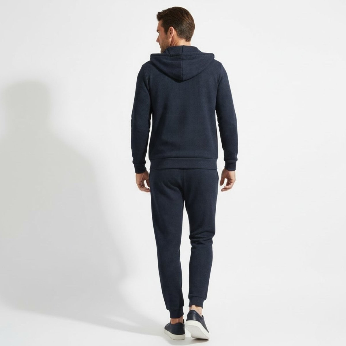 Back view of the Kouvr Case waffle knit zip hoodie and matching slim fit joggers in navy blue.