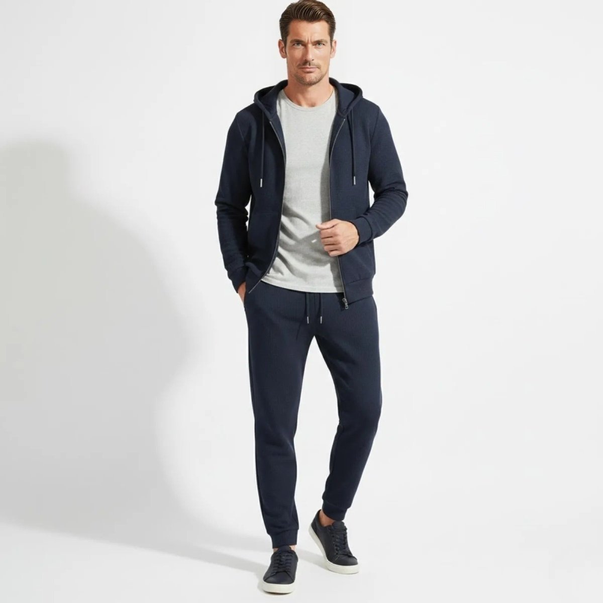 Man wearing the Kouvr Case blue waffle knit zip hoodie and jogger tracksuit set, facing forward.