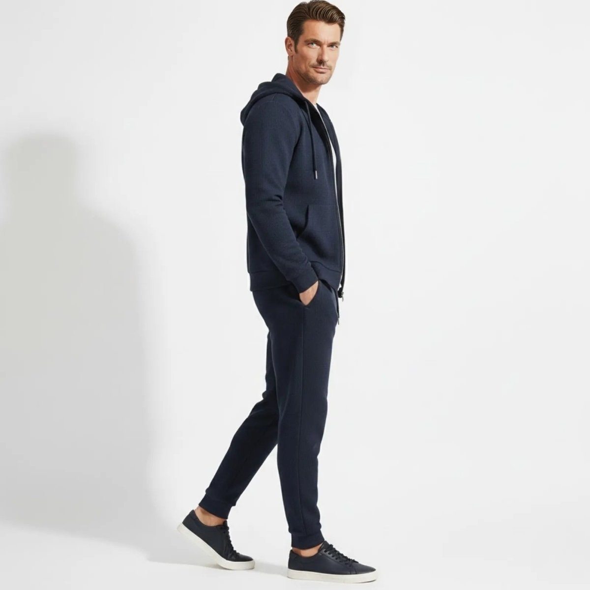 Side profile of a man walking in the Kouvr blue textured cotton athleisure co-ord set.