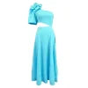 Model standing on a staircase wearing the Kouvr light blue one-shoulder dress with a large flower detail and side cutout