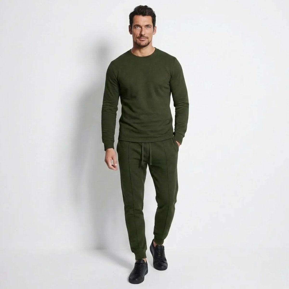 Man wearing the Kouvr Crue Lounge Set in army green, walking towards the camera on a white background. 