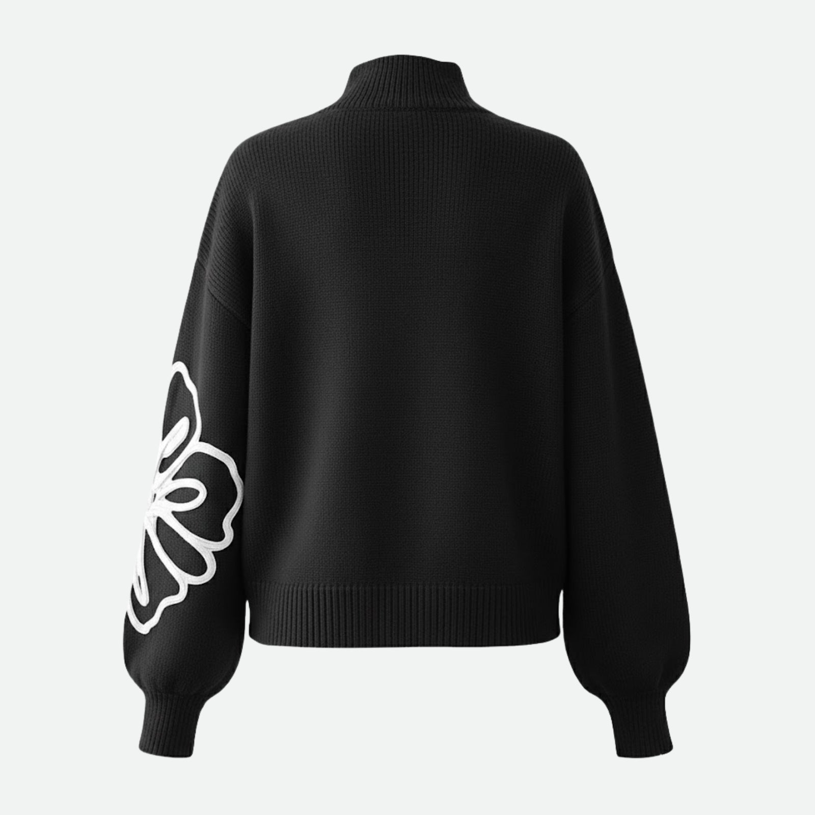 Back view of the Kouvr Cynthia sweater laid flat, showing the clean back and the continuation of the floral embroidery on the sleeve.
