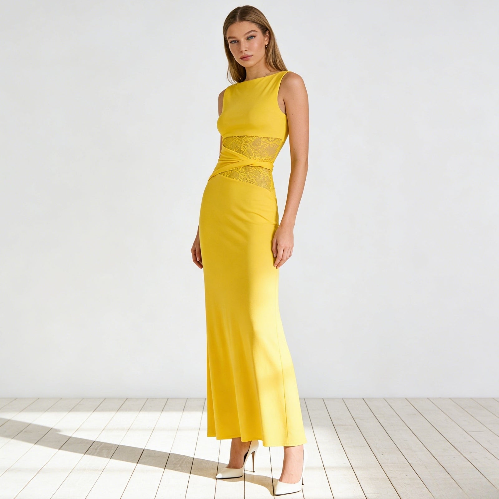 Model wearing the Kouvr Fashion Deborah sleeveless yellow cut out midi dress with sheer lace waist panels, paired with red heels, on a white background.