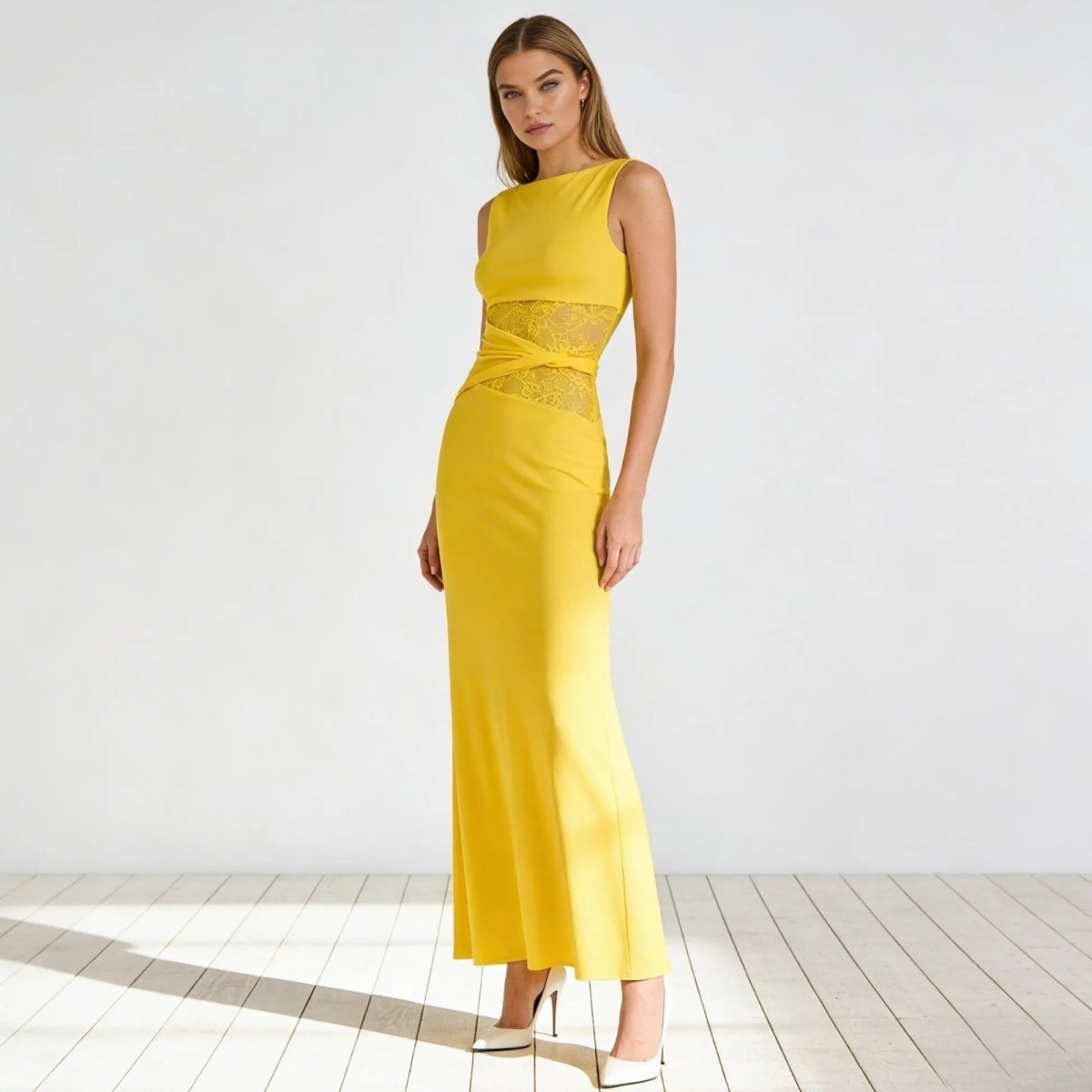 Model wearing the Kouvr Fashion Deborah sleeveless yellow cut out midi dress with sheer lace waist panels, paired with red heels, on a white background.