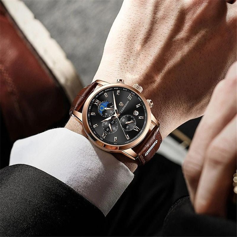 The white dial Kouvr Dexter Chronograph watch on a wooden desk next to a pen and a book, highlighting its executive appeal.