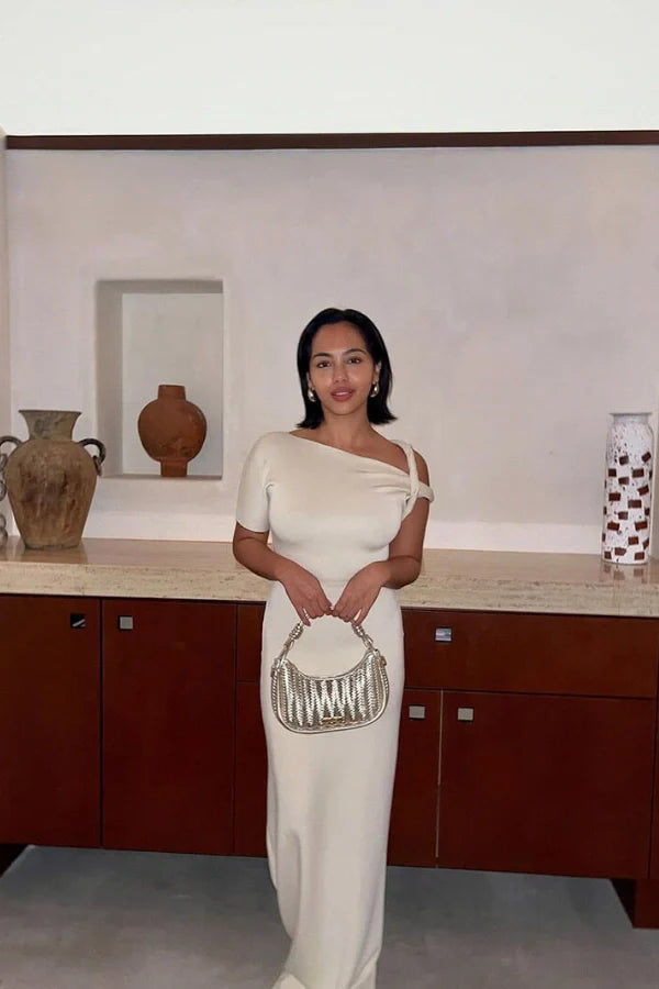 Naturally include related terms like `sculptural silhouette`, `figure-hugging`, `single sleeve gown`, `elegant formalwear`, and `resort evening dress