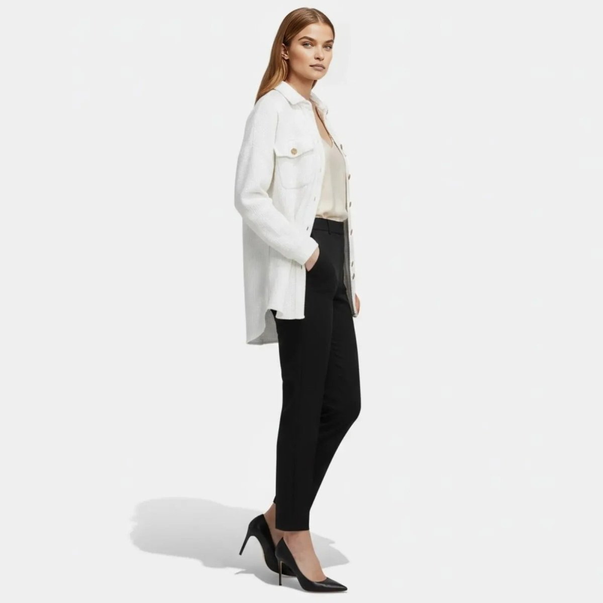 Side profile of a model wearing the white Kouvr Donna shacket, showcasing its longline silhouette and relaxed fit with hands in pockets.
