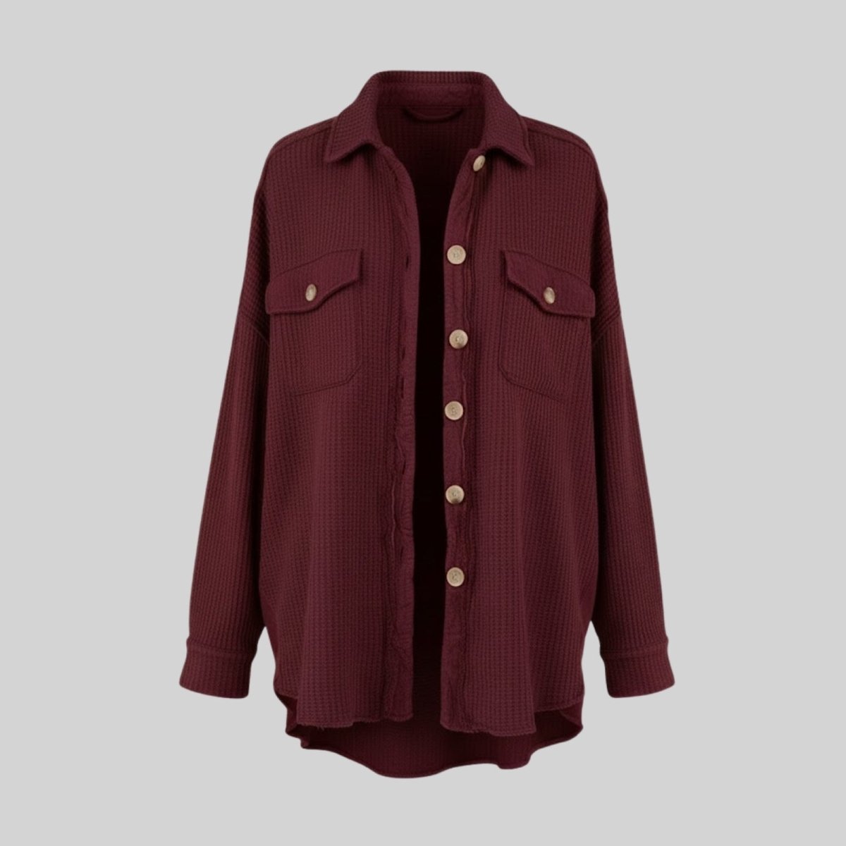 Flat lay product shot of the front of the burgundy waffle knit shirt jacket, with buttons and chest pockets clearly visible.
