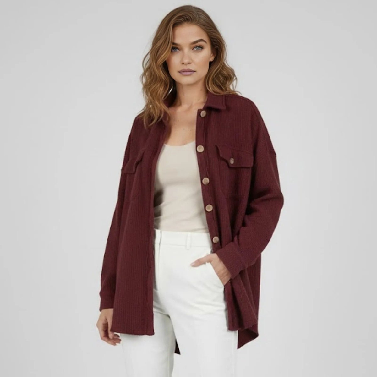 Model wearing the oversized burgundy waffle knit Donna shacket open over a cream tank top and white pants, showing its relaxed fit.