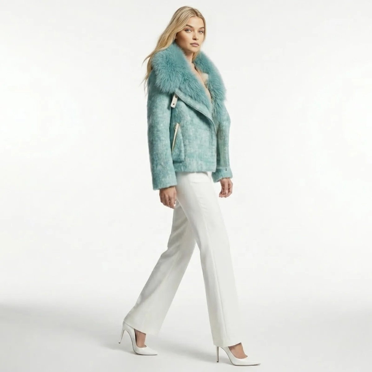 Model in a side profile walking pose wearing the Kouvr Dorothy blue biker jacket, showing the jacket's silhouette and movement.
