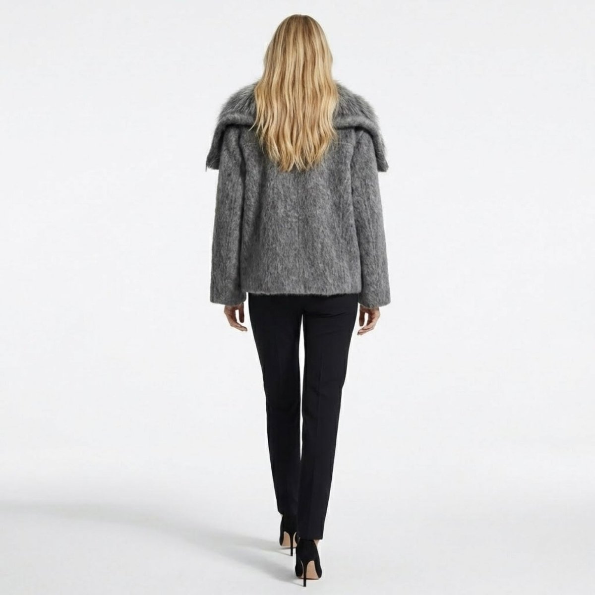 Back view of the Kouvr Dorothy dark grey wool jacket, showing the shape of the oversized collar and the textured fabric on a female model.
