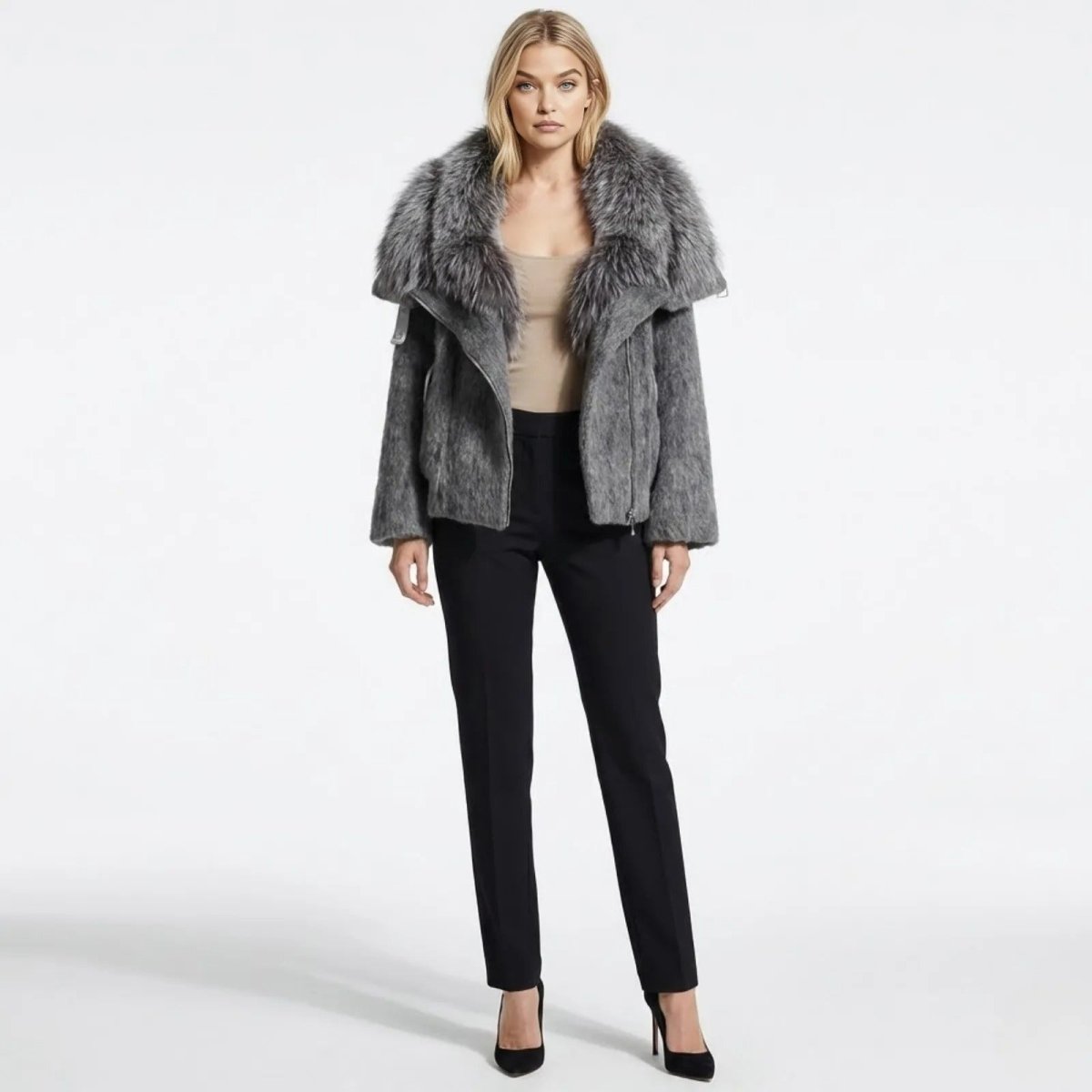 A female model wearing the Kouvr Dorothy dark grey wool moto jacket with a large faux fur collar, paired with black trousers and heels, shown from the front.