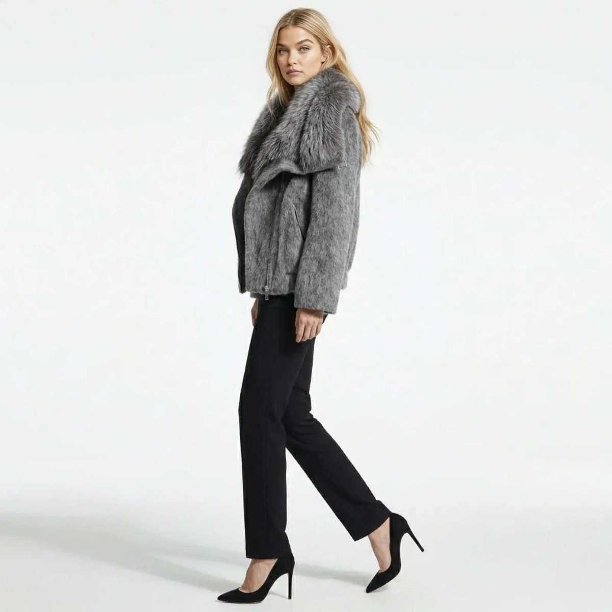Side profile of a model walking in the Kouvr Dorothy dark grey wool biker jacket, highlighting the silhouette and plush faux fur collar detail.