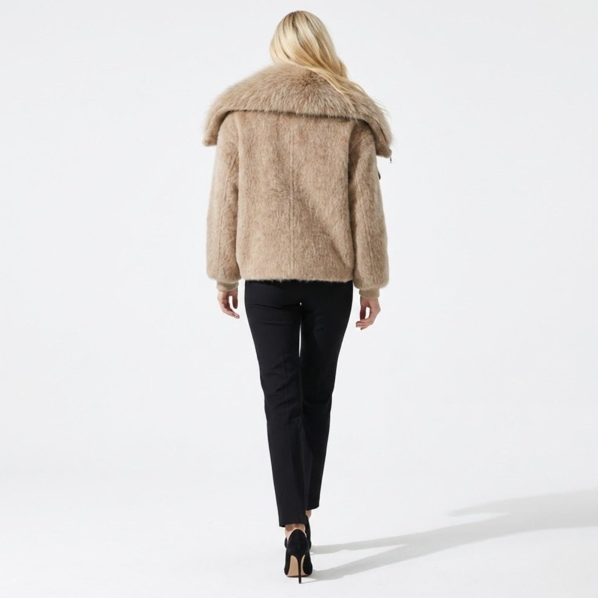 Back view of the Kouvr Dorothy warm winter jacket in beige, highlighting the plush texture and wide faux fur collar.
