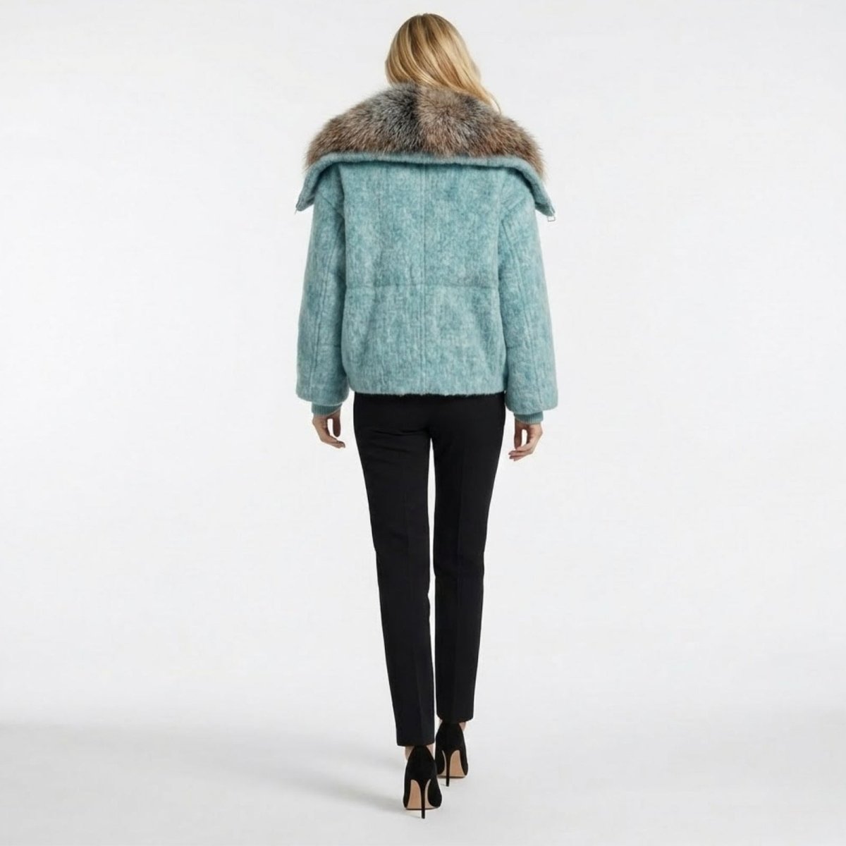 Back view of the Kouvr Dorothy jacket in light blue, highlighting the large fox fur collar and quilted wool texture.
