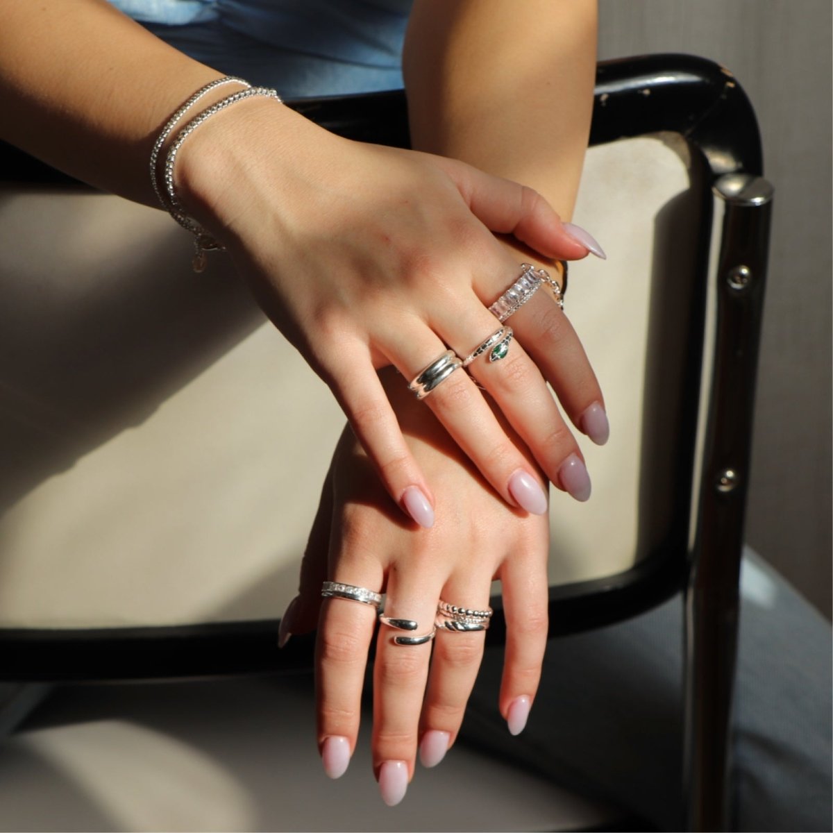 Model wearing the silver Kouvr Double Dome Ring stacked with other gold statement rings.