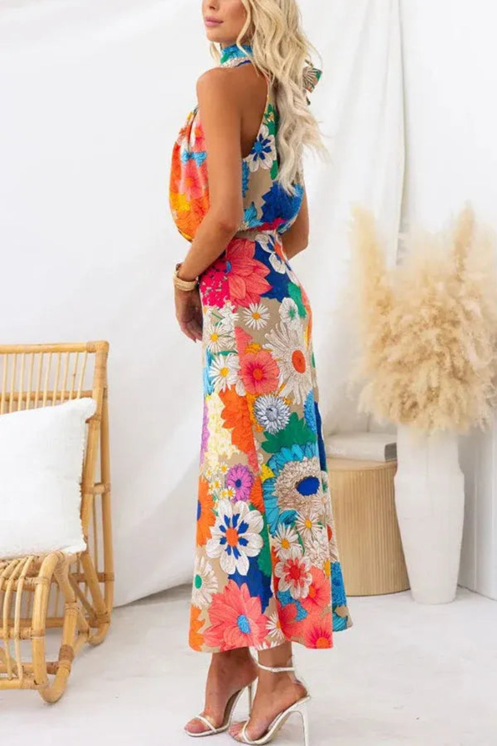 Model wearing the Kouvr Elisha colorful floral halter maxi dress in a bright room