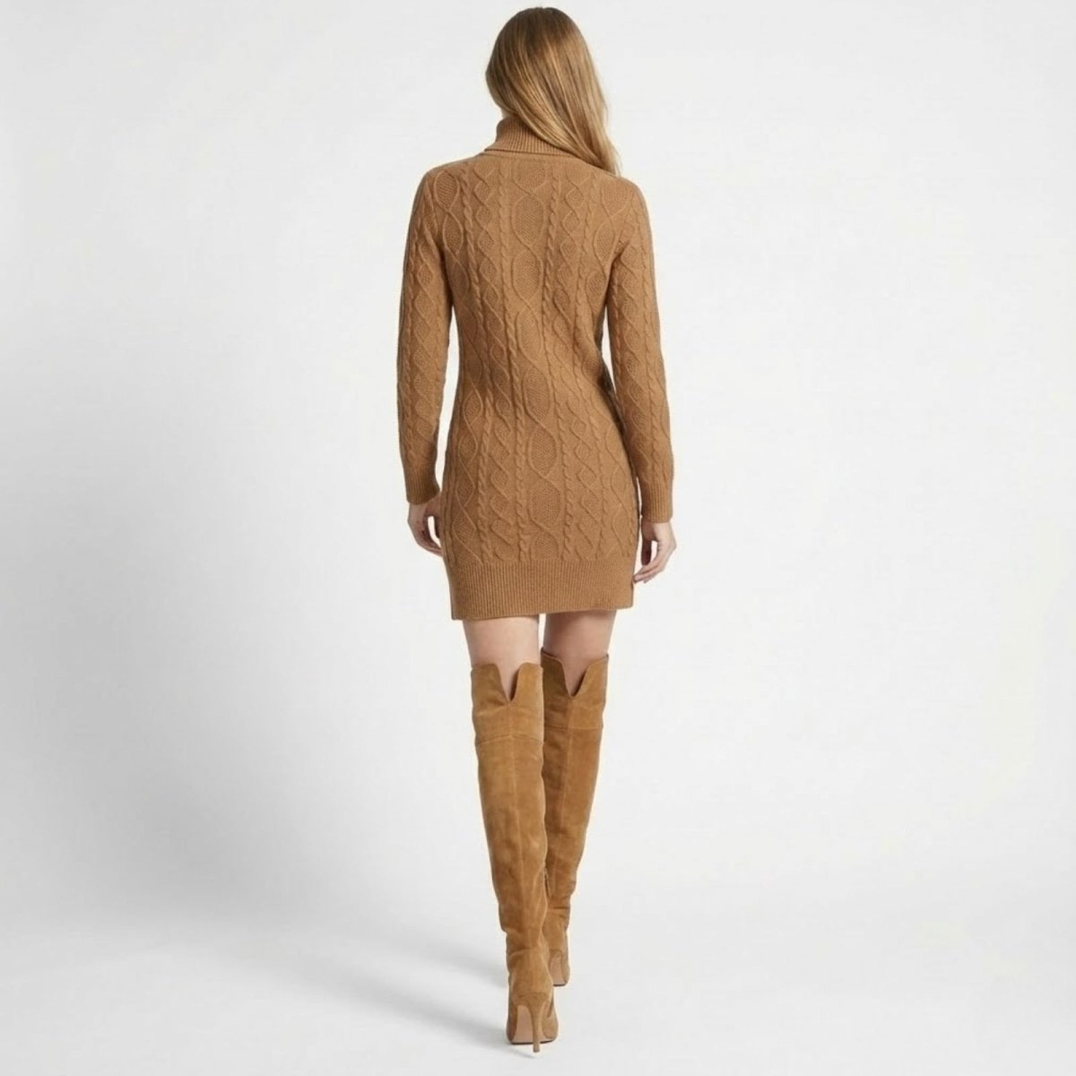 Back view of a model in the Kouvr Erza camel turtleneck dress, highlighting the continuous cable-knit pattern.