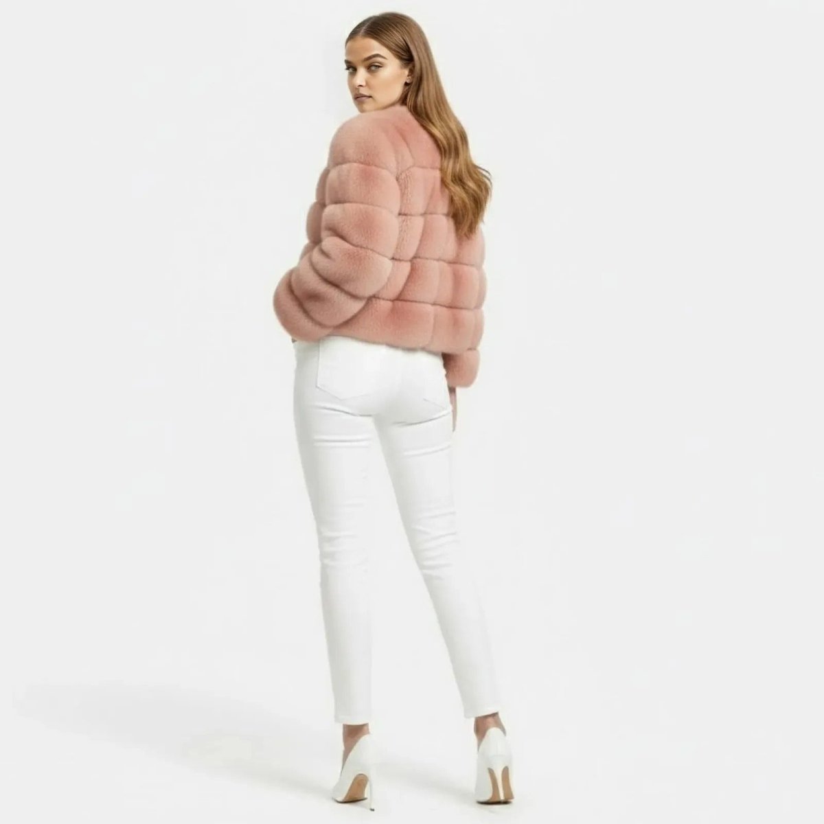 Back view of a model wearing the collarless blush pink Alexia faux fur jacket from Kouvr Fashion, showing the horizontal panel construction.