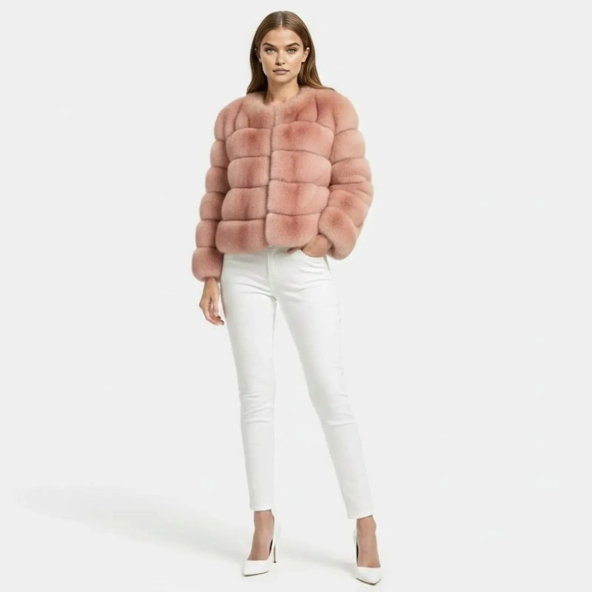 Model wearing the Alexia blush pink faux fur jacket by Kouvr Fashion, paired with white jeans and heels, shown from the front.