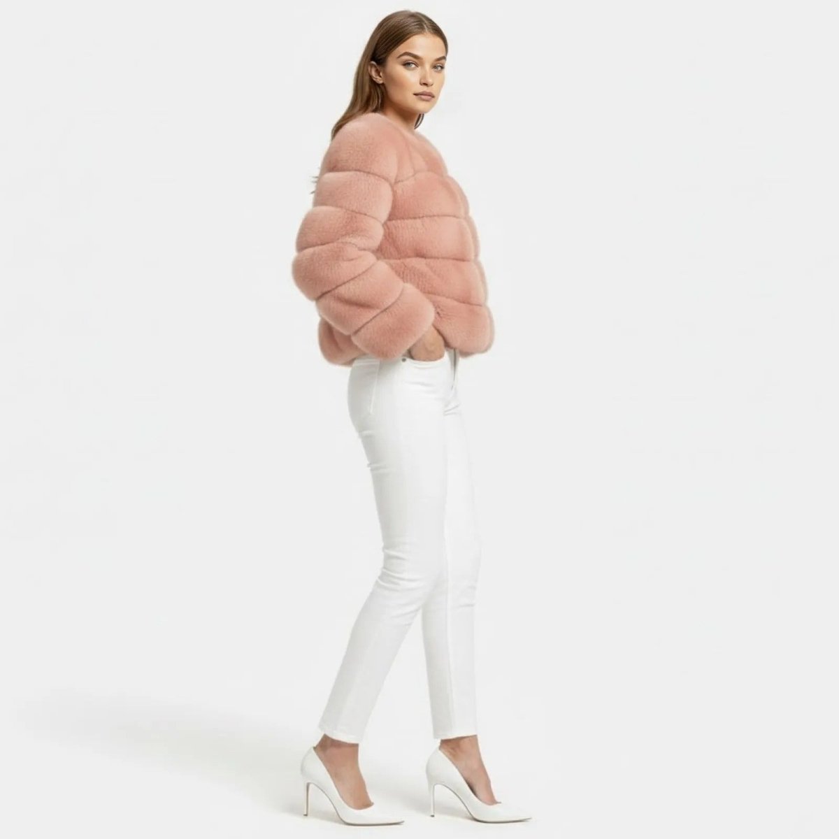 Side profile of a model in the short, paneled blush pink faux fur Alexia jacket from Kouvr Fashion, highlighting its texture and silhouette.