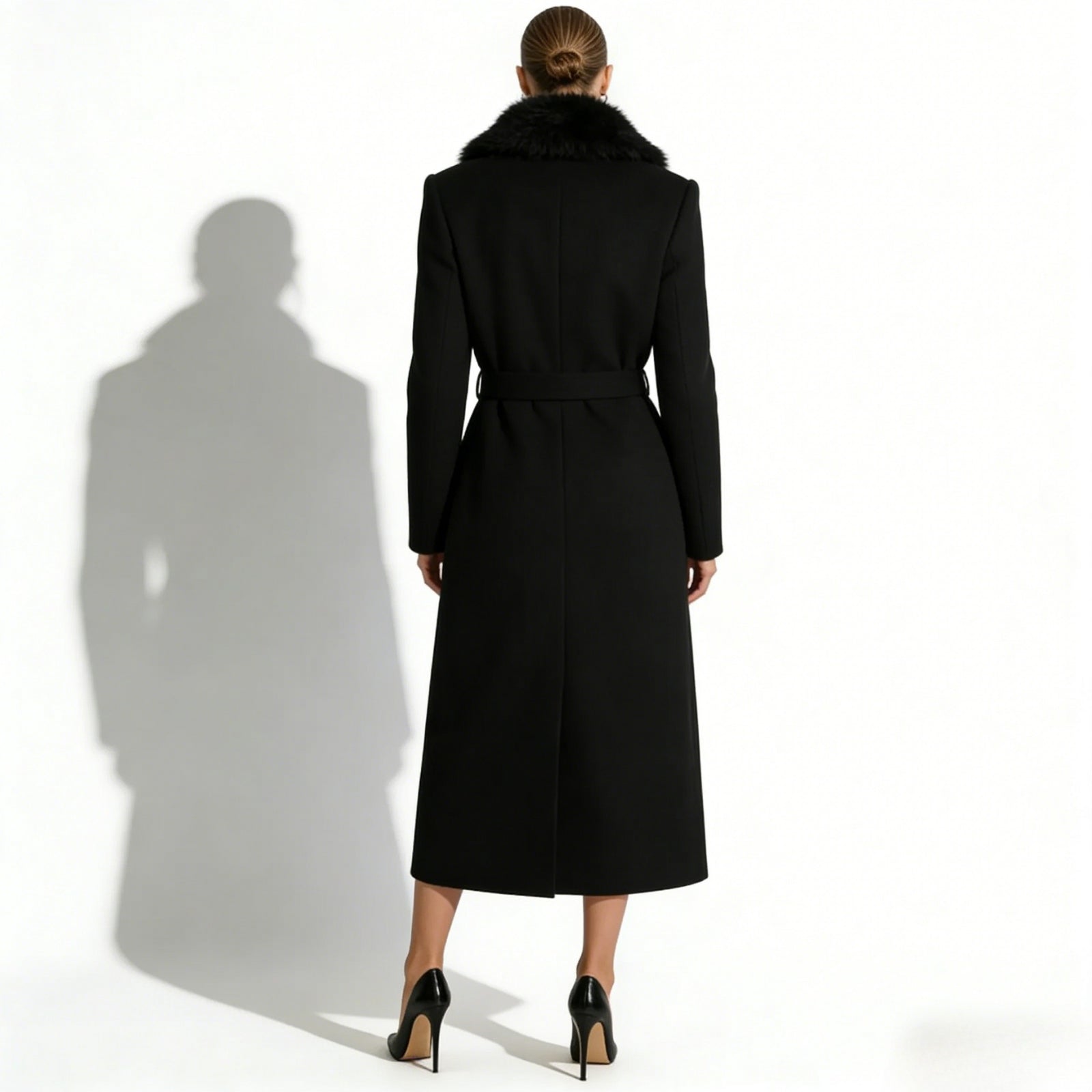 Back view of a model wearing the Kouvr Fashion black wool maxi coat, showing the tailored fit and self-tie belt.