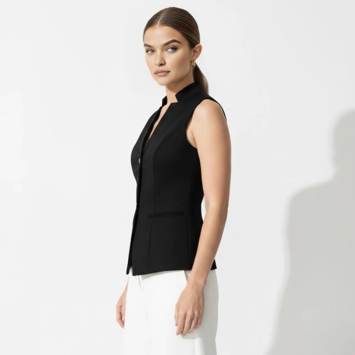 Side profile of a model in the Kouvr Fashion fitted black sleeveless blazer vest, highlighting its tailored silhouette.