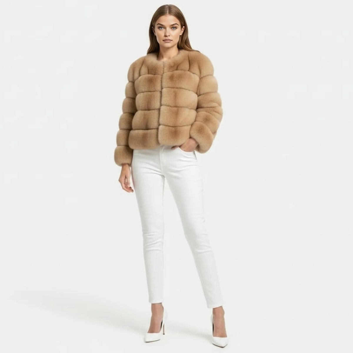 Model wearing a camel cropped faux fur collarless jacket with white jeans and white heels, full front view.