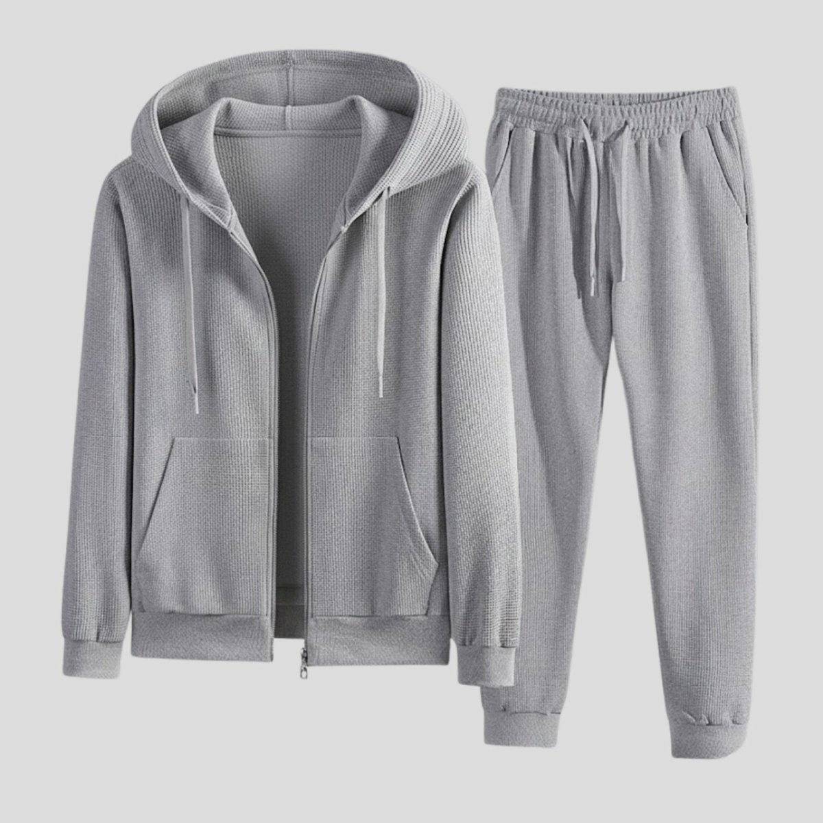 Flat lay of the Kouvr Fashion men's tracksuit in heather grey, showing the waffle-knit zip hoodie and matching jogger pants side-by-side.