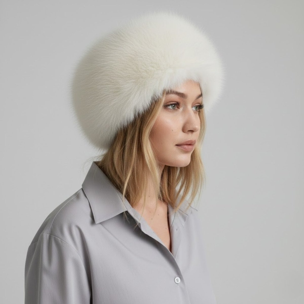 Woman wearing a beige fur hat against a light gray background