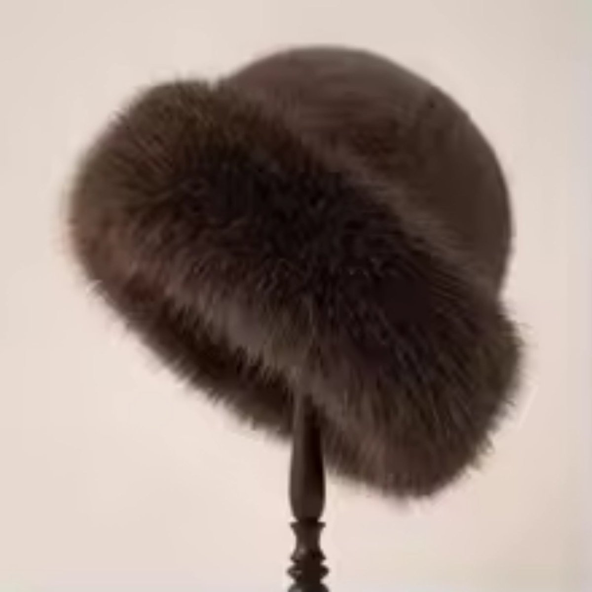 Brown fur hat on a mannequin head against a beige background