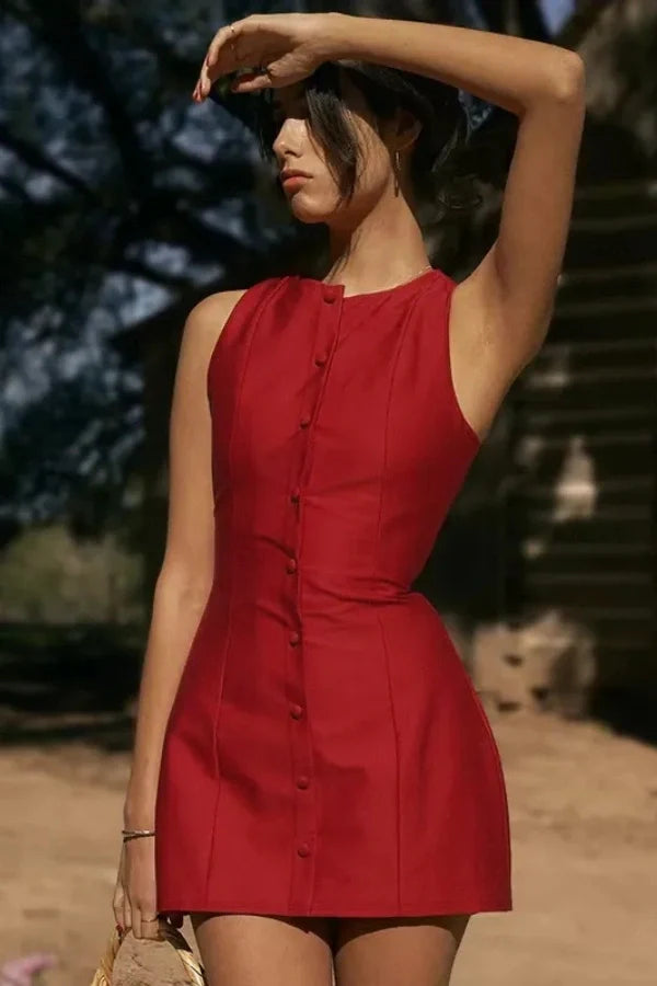 Model wearing the Kouvr Cosette sleeveless red mini dress in a rustic setting