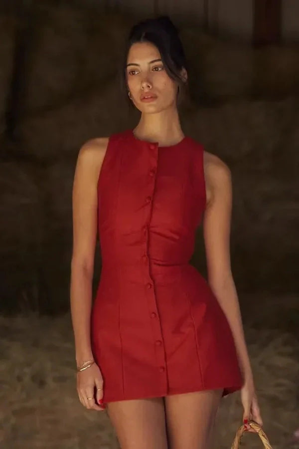 Model wearing the Kouvr Cosette sleeveless red mini dress in a rustic setting