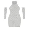Model wearing the Kouvr Fashion silver crystal embellished sheer halter mini dress with matching long sleeves against a white background