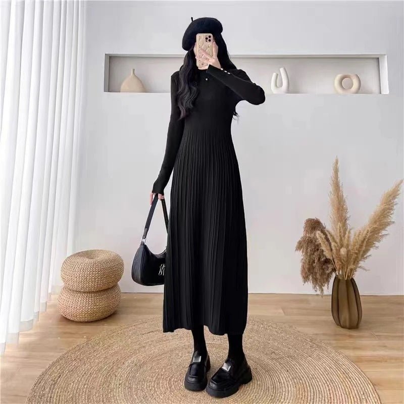Full-length view of a woman in the black Dannah pleated knit dress by Kouvr Fashion, paired with a black beret and chunky loafers for a chic look.