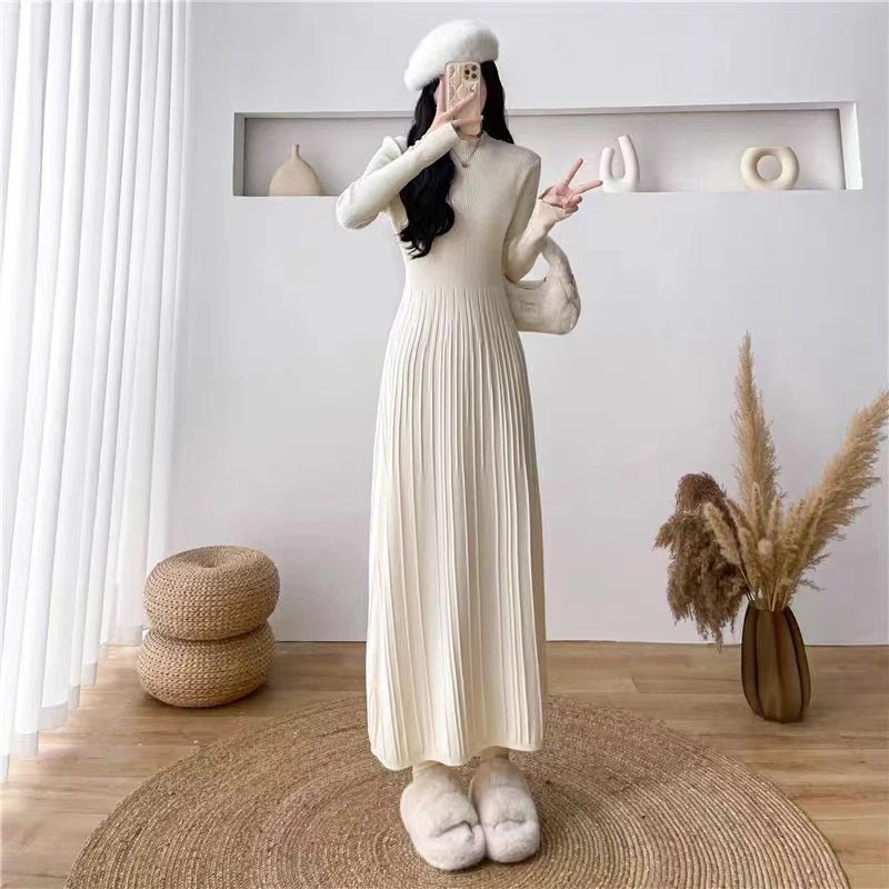 Model posing with the ivory pleated knit dress by Kouvr Fashion.