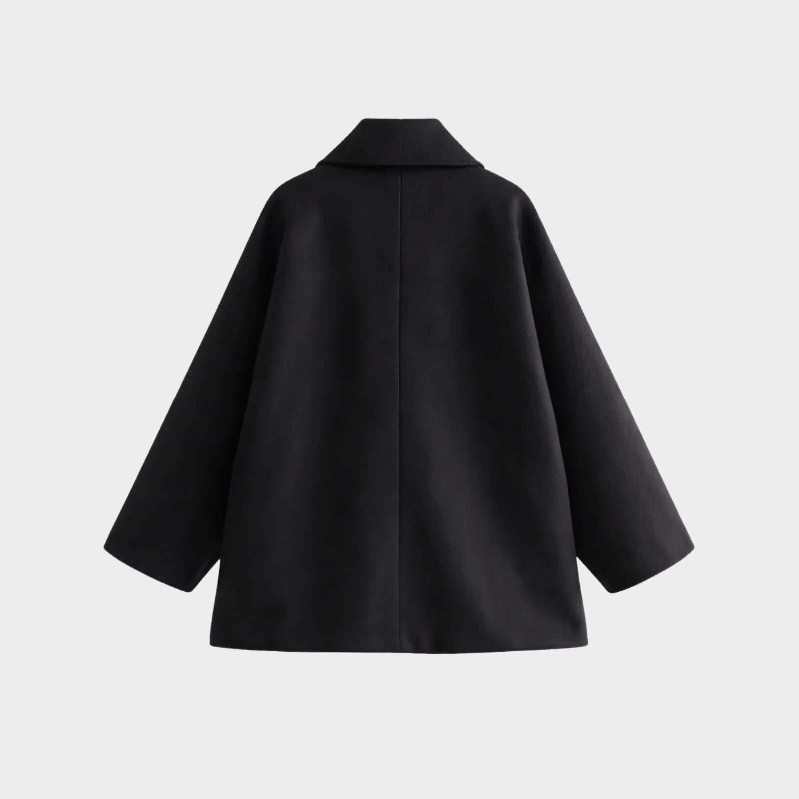Flat lay of the back of the Kouvr Fashion oversized black wool peacoat, showcasing the structural tailoring and clean seams.