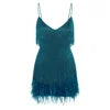 Model from behind wearing the Kouvr Elena teal mini dress, showing the movement of the metallic fringe and feather trim